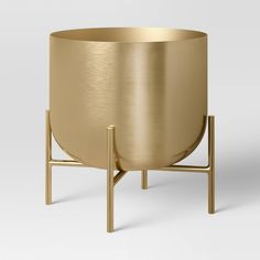 a gold metal planter on a stand