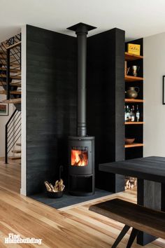 a wood burning stove sitting inside of a living room next to a table and stairs