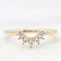 a yellow gold ring with three diamonds on the top, and two smaller ones in the middle