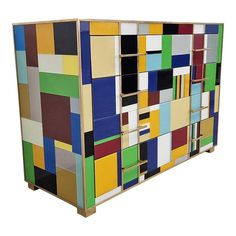 a multicolored wooden cabinet with multiple compartments and shelves on each side, all painted in different colors