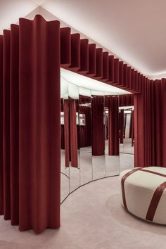 a room with mirrors and red curtains on the walls