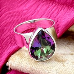 Mystic Topaz Ring, Sterling Silver Ring, Statement Ring, Teardrop Ring, Rainbow Fire Mystic Topaz Ring, handcrafted jewelry, Gift For Her *Main Stone :Mystic Topaz *Main Stone Color : Purple *Main Stone Creation : Lab Created Gemstone *Metal : Sterling Silver *Base Metal : 925 parts per 1000 *Style : Ring What Are The Benefits of Silver Jewelry Silver has a long history in antibiotics and sterilization, with many women and men wearing silver jewelry to stave off infection, cold/flu symptoms, and Teardrop Amethyst Ring For Gift, Teardrop Topaz Ring Gift, Teardrop Topaz Ring For Gift, Handmade Teardrop Crystal Ring Gift, Topas Ring, Ring Teardrop, Mystic Topaz Ring, Rainbow Fire, Teardrop Ring