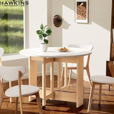 there is a small white table and chairs in the room with wood flooring on the wooden floors