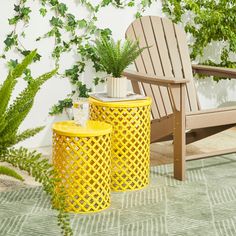 two yellow trash cans sitting on top of a green rug next to a wooden chair