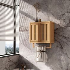 a bathroom with marble walls and flooring has a wooden cabinet on the wall above it