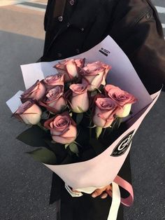 a man holding a bouquet of pink roses