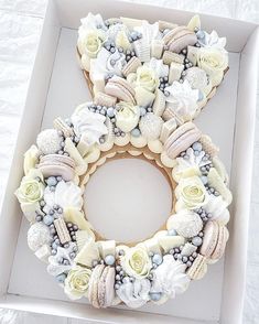 a white box with a wreath made out of seashells and flowers on it