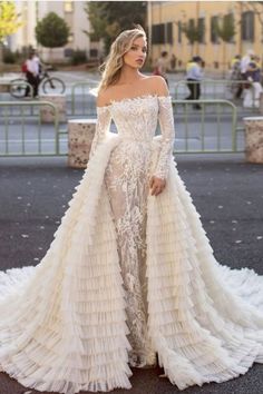 a woman in a wedding dress standing on the street