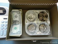 an open box with money and silver foil in it next to a calculator