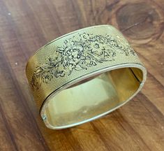 Vintage floral Victorian inspired gold cuff bracelet 1/10 14 karat gold CLAP. The bracelet is one inch thick, 8 inches in diameter, weighs 1.3 ounces and is etched with a beautiful floral pattern on both sides. I discovered this bracelet in my mother's jewelry box after she passed away. She was born in 1940 and this bracelet was purchased and worn in the 1960s. There is a small dent on one side in the floral design from wear, but is otherwise it is in good vintage condition. Gold Cuff Bracelet, Mother Jewelry, Gold Bracelet Cuff, Gold Cuffs, One Inch, Vintage Floral, Cuff Bracelet, Cuff Bracelets, Jewelry Box