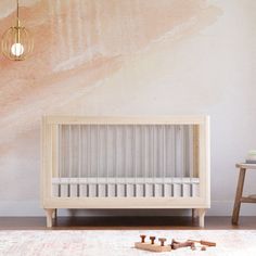 a baby crib sitting on top of a rug next to a wooden table