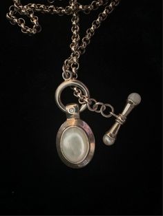 "Stunning and substantial. A thick rolo chain (4mm) holds a mother of pearl pendant and oversized toggle clasp, which can allow the wearer to adjust the length of the necklace. Stamped .925 Thailand. Pendant has one inset cz. 33.38 g Lariat chain is 20\" long." Elegant Toggle Necklace With Adjustable Oval Link Chain, Elegant Oval Link Toggle Necklace, Luxury Silver Pendant Lariat Necklace, Timeless Formal Toggle Necklace With Adjustable Chain, Elegant Metal Toggle Necklace With Oval Link, Elegant Toggle Necklace With Lobster Clasp For Formal Occasions, Elegant Toggle Necklace With Adjustable Chain, Luxury Toggle Necklace For Formal Occasions, Classic Metal Jewelry With Pearl Pendant