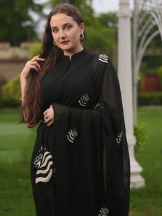 This is a three-piece black zebra saree set from the Ensembles collection. The black zebra saree is paired with a black sleeveless blouse. The blouse has front potli button opening, and a mandarin collar. There are beautiful zebra motifs of black and white bead work all over the saree. This saree set is crafted in pure organza fabric with contrast piping border. The outfit is completed with a heavily embellished, beadwork black and white zebra shape handbag. Elegant Black Saree For Eid, Black Designer Blouse Piece For Eid, Designer Black Blouse Piece For Eid, Designer Wear Black Blouse For Eid, Unstitched Black Blouse Piece, Black Saree Blouse Piece For Eid, Black Anarkali Pre-draped Saree For Eid, Elegant Black Blouse For Eid, Elegant Black Pre-draped Designer Saree