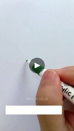 someone is writing on a piece of paper with a green marker and white eraser