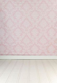 an empty room with pink wallpaper and white flooring in the foreground is a teddy bear