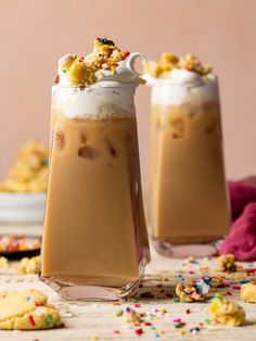 two glasses filled with ice cream and sprinkles on top of a table