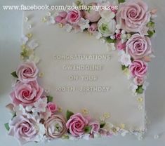 a sheet cake decorated with pink roses and white frosting on top of a table