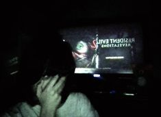 a person holding their head in front of a television screen with the evil dead clown on it