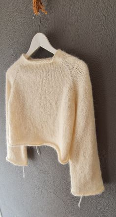 a white sweater hanging up on a wall