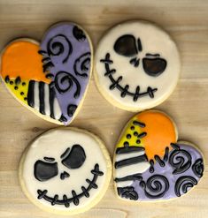 three decorated sugar cookies sitting on top of a wooden table