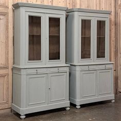 two gray china cabinets sitting next to each other