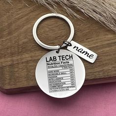 a metal keychain with the words lab tech on it and a furry tail