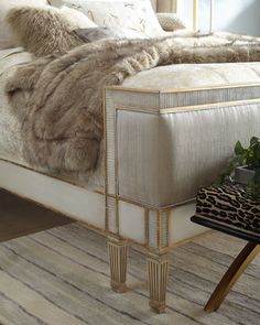 a bed with a leopard print pillow on top of it next to a side table