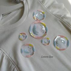 four bubbles on top of a white shirt