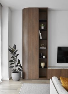 a living room filled with furniture and a flat screen tv on top of a wooden shelf