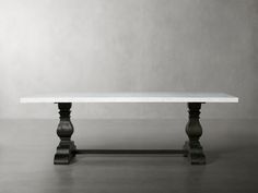 a white table sitting on top of a cement floor next to a black and white wall