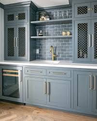 a kitchen with gray cabinets and gold pulls