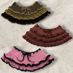 three crocheted skirts with ruffles on them sitting on a white surface