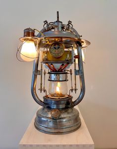 an old fashioned lamp with two lights on it's sides and a clock in the middle