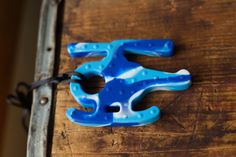 a blue and white plastic object sitting on top of a wooden table