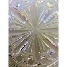 a clear glass vase sitting on top of a table next to a white plate with silver trim