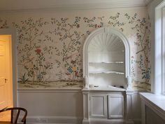 a room with a wallpapered mural in the corner