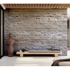 a living room with a couch and table in front of a brick wall that looks like it has been built into the ground