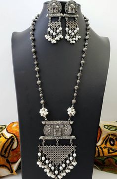 German silver Indian pendant necklace with Taj Mahal in 3D, and a beautiful geometric pendant with faux pearl dangling ghungroo. In a soft grey color with the patina of a vintage piece. Realistic faux pearls Excellent quality and craftsmanship. Necklace measures 12 inch drop. Pendant measures 4.5 inches by 3 inches. View more necklaces here: https://www.etsy.com/shop/BoutiqueByMaryam?section_id=21694658 Be sure to visit the rest of my shop here: https://www.etsy.com/shop/boutiquebymaryam Bohemian Silver Jewelry With Pearl Chain, Traditional White Necklace With Oxidized Finish, Traditional Silver Jewelry With Pearl Pendant, Traditional White Oxidized Finish Necklace, Traditional White Necklaces With Oxidized Finish, Gift Silver Temple Necklace With Pearl Chain, Festive Silver Necklace With Pearl Pendant, Bohemian White Necklaces With Latkans, White Bohemian Necklaces With Latkans