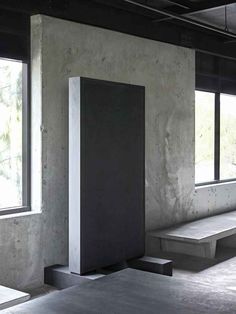 an empty room with concrete benches and windows