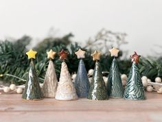 small christmas trees are lined up on the table