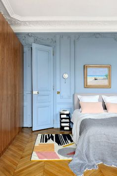 a bedroom with blue walls and wooden floors