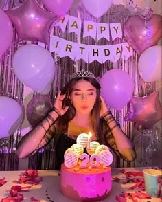 a woman sitting in front of a birthday cake