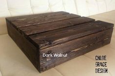 a wooden box sitting on top of a white couch with the words dark walnut above it