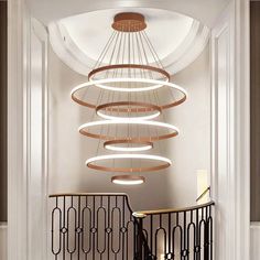 a spiral light fixture hanging from the ceiling in a hallway next to a stair case