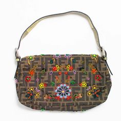 This Fendi Beaded Baguette is crafted from brown Zucca canvas with silver-tone hardware and python leather accents and shoulder strap. Featuring multi-color beaded embellishments throughout. Satin lining with zipper pocket at interior and magnetic logo closure at front. Measuring: 10.25 in. L, 6.75 in. H, 1.5 in. D. Very good condition: Beaded Embellishments, Leather Accents, Python, Zipper Pocket, Embellishments, Silver Tone, Shoulder Strap, Fendi, Multi Color