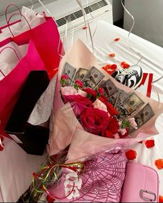 flowers and money are on the bed with pink bags