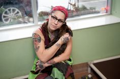 a woman sitting on the floor holding a cat