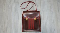 Retro leather shoulder bag, in brown and red color. Produced in 1980, the bag has three internal compartments - one large main compartment and two smaller ones. Used but in very good condition, no tears or missing or damaged parts. Suitable for carrying books, documents, a tablet or a small laptop. Approximate sizes:  Length: 27 cm (10.6 in.) Width: 9 cm (3.5 in.) Height: 33 cm (13 in.) Weight: 753 grams All photos are real. You buy what see on the photos We only offer vintage items that almost always have some type of wear and tear such as scratches, cracks, missing paint, corrosion and more. These imperfections only add style to the retro appeal. We always try to describe and show pictures of any damage or wear. Please review the photos carefully as part of the product description. Your Brown Crossbody Shoulder Bag For School, Retro School Shoulder Bag, Rectangular Brown Student Bag, Brown Satchel Shoulder Bag For School, Brown Rectangular Shoulder Bag For School, Brown Tote Shoulder Bag For School, Rectangular Brown Shoulder Bag For School, Vintage Leather Backpack-style Shoulder Bag, Vintage Crossbody Shoulder Bag For School