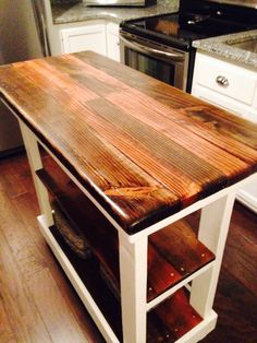 a kitchen island made out of wood and white cabinets