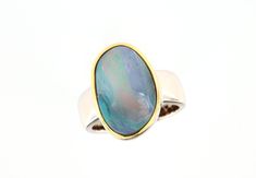 A simple, classic opal ring crafted in solid sterling silver. The ring has an Australian boulder opal from Queensland with a light blue-turquoise fire. There is also a red line running through the stone, which makes the boulder opal glow. The setting edge is gold-plated so that the stone is beautifully highlighted. The silver ring shank is 7-5.5mm wide.  Opal type: Boulder opal Origin/Place of discovery: Queensland, Australia Carat weight: 8.70ct, 20.5x15mm Metal: 925 silver, gold-plated setting Modern Oval Opal Ring, Opal Rings With Polished Finish For Formal Occasions, Formal Opal Rings With Polished Finish, Modern Opal Ring For Anniversary, Modern Oval Cabochon Opal Ring As Gift, Formal Opal Ring With Polished Finish, Formal Opal Open Ring, Formal Sterling Silver Opal Ring Oval Cabochon, Formal Sterling Silver Opal Ring With Oval Cabochon